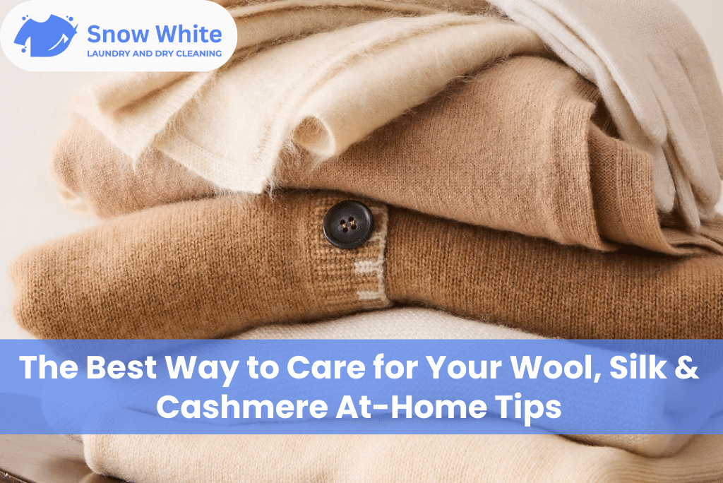 Soft wool, silk, and cashmere clothes neatly folded with Snow White Laundry and Dry Cleaning Service in London branding